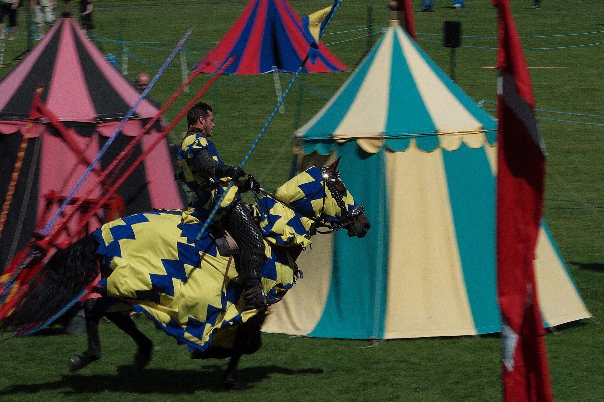 Two riders jousting in front of a standing crowd.